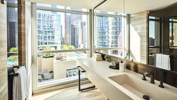 A modern bathroom with a large window, a sink, and a mirror.