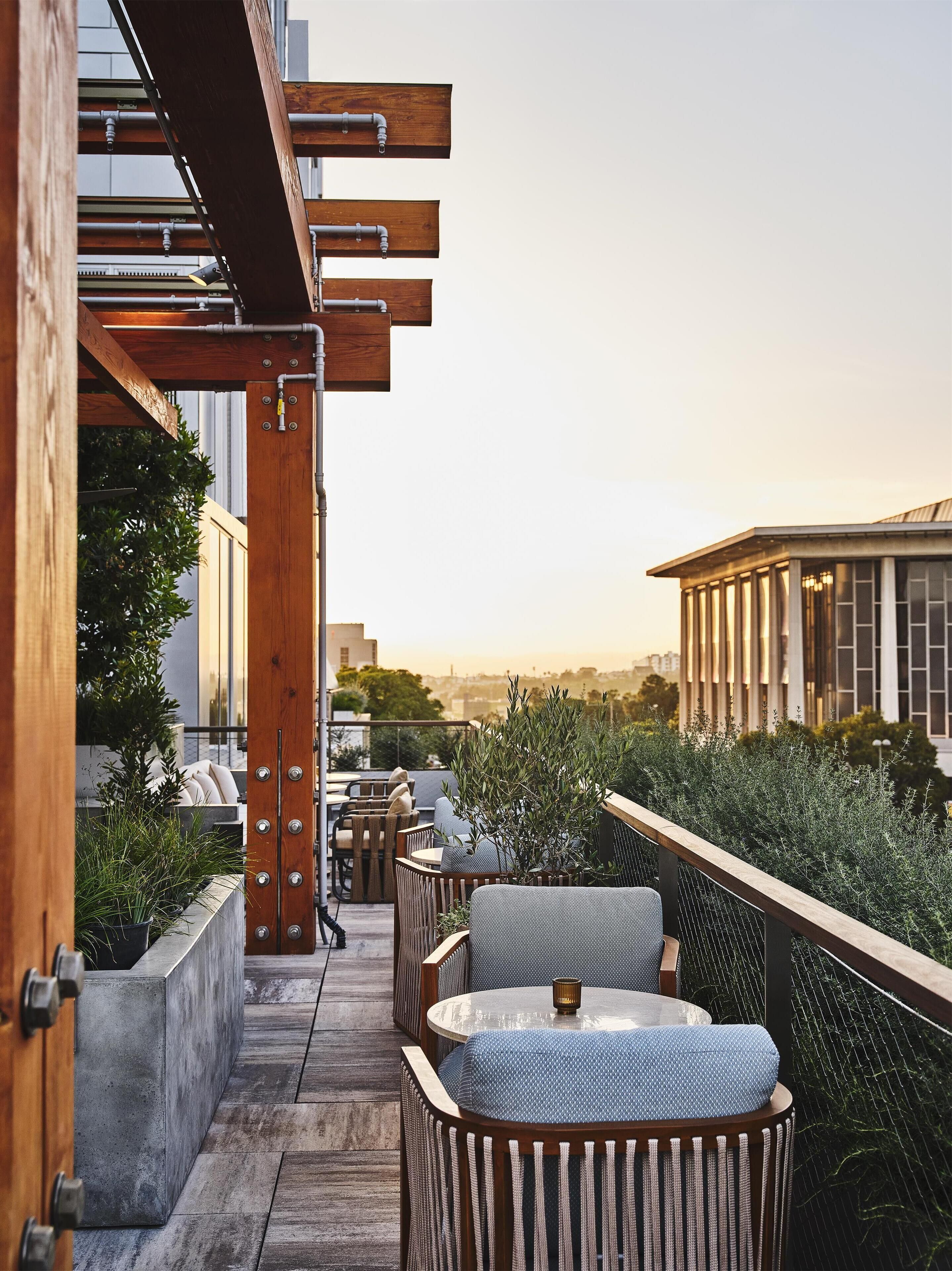 An outdoor terrace with wooden pergolas, seating areas, and potted plants.