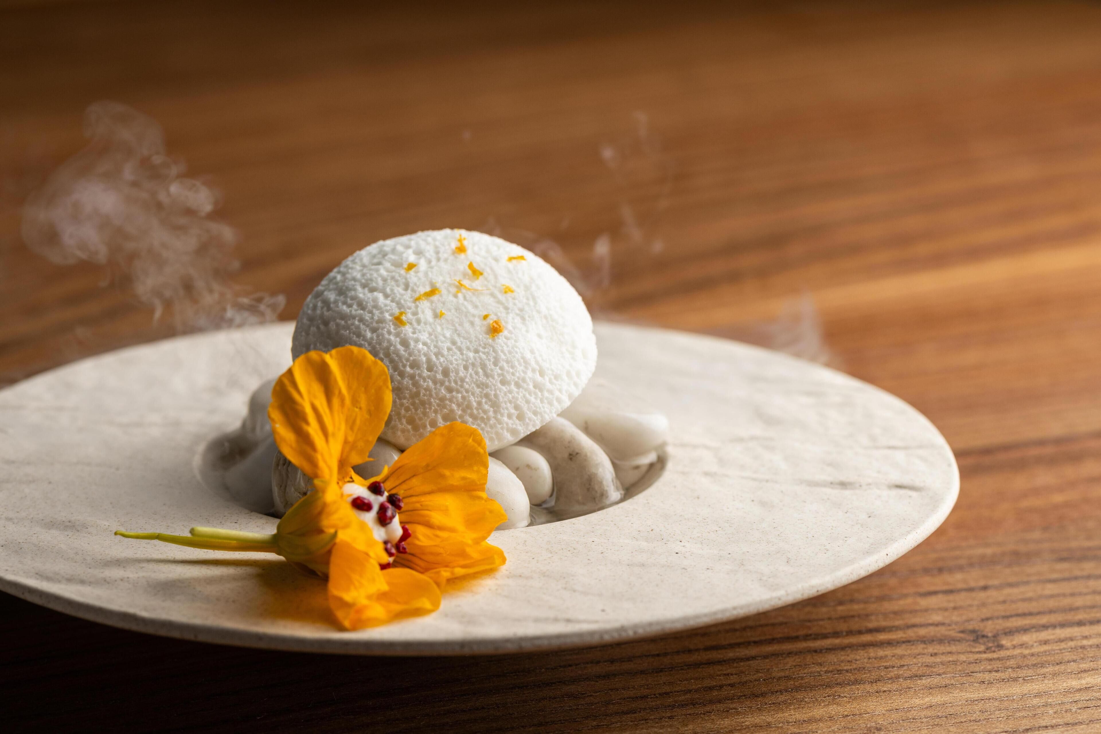 A dessert on a plate with a flower.