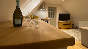 A modern kitchen with a wooden countertop, a bottle of Corte Molino Prosecco, and a glass decanter.
