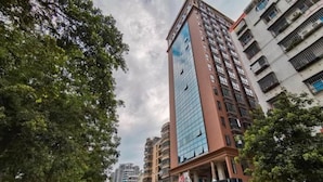 A multi-story building with a glass facade and a sign indicating a restaurant on the ground floor. - Borrman Hotel (Guilin)