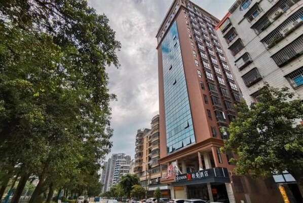 A multi-story building with a glass facade and a sign indicating a restaurant on the ground floor. - Borrman Hotel (Guilin)