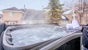 A hot tub with a view of residential houses in the background.