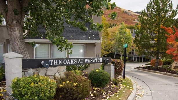 A sign for "The Oaks at Wasatch" with a landscaped garden in front.