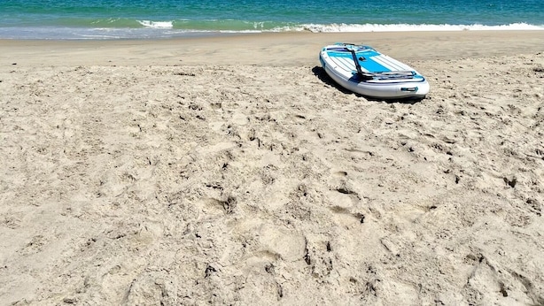 A beach with a single blue and white surfboard lying on the sand. - 4BR 3 Bath, Dog Friendly, Linens & Towels provided, 700ft to beach access (Kill Devil Hills)