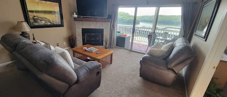 A living room with a fireplace, two leather sofas, a coffee table, and a TV.