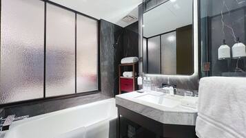 Un baño moderno con una bañera, un lavabo con espejo y un perchero para toallas.