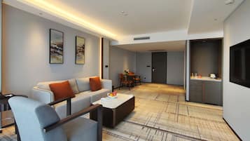 Una sala de estar moderna con sofá, sillones, una mesita de centro y un comedor con sillas y mesa.