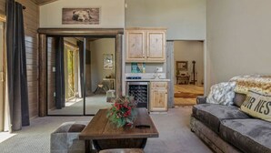 A spacious living area with a wooden table, a sofa, and a kitchen in the background. - Eagle Creek Lodge w/Spa (Big Bear Lake)
