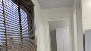 En smal hall med ett fönster på vänster sida och en dörr längst fram.