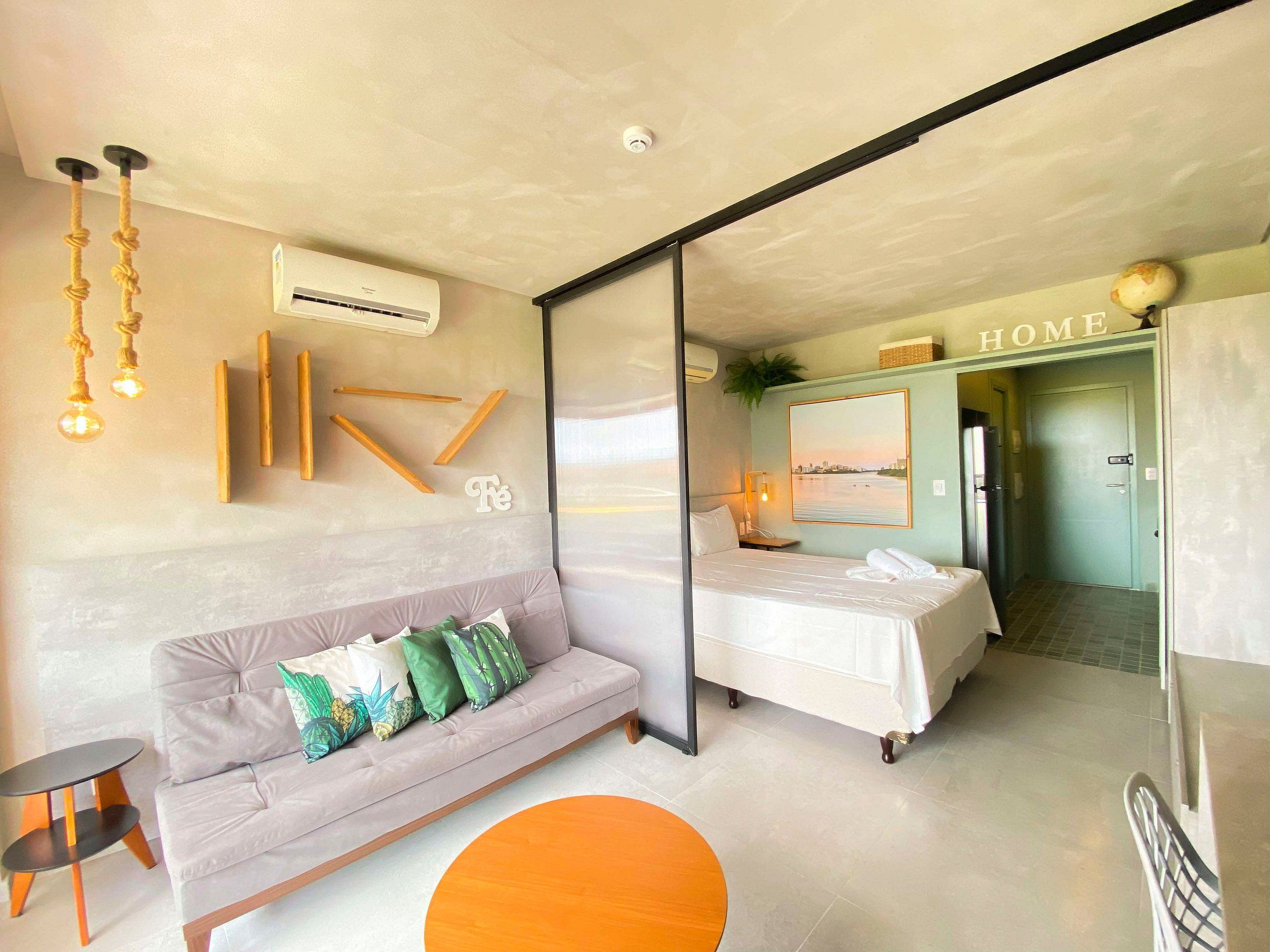 A modern bedroom with a sofa, bed, and a small table.