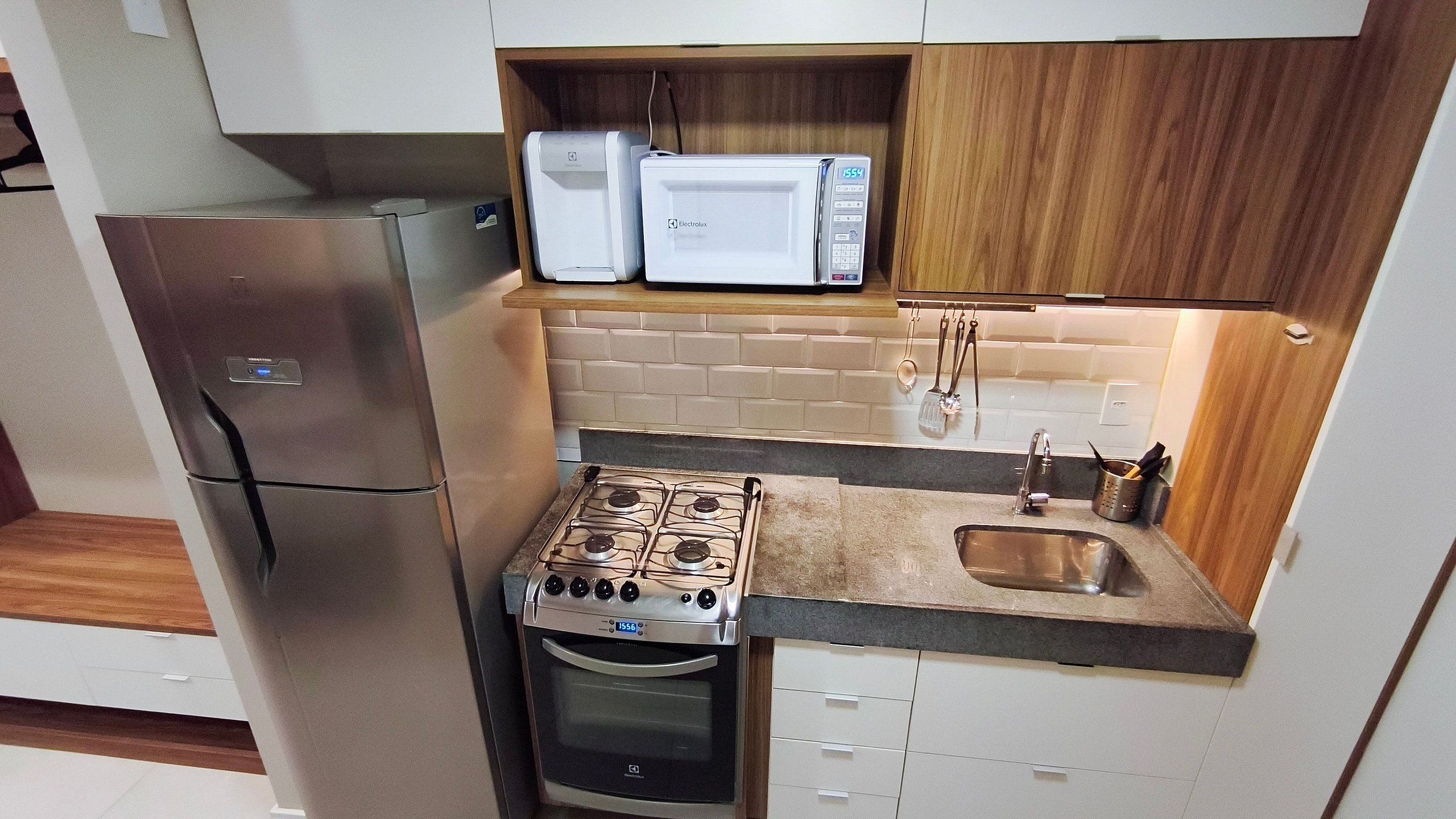 A compact kitchen with a built-in microwave, a stove, and a refrigerator.