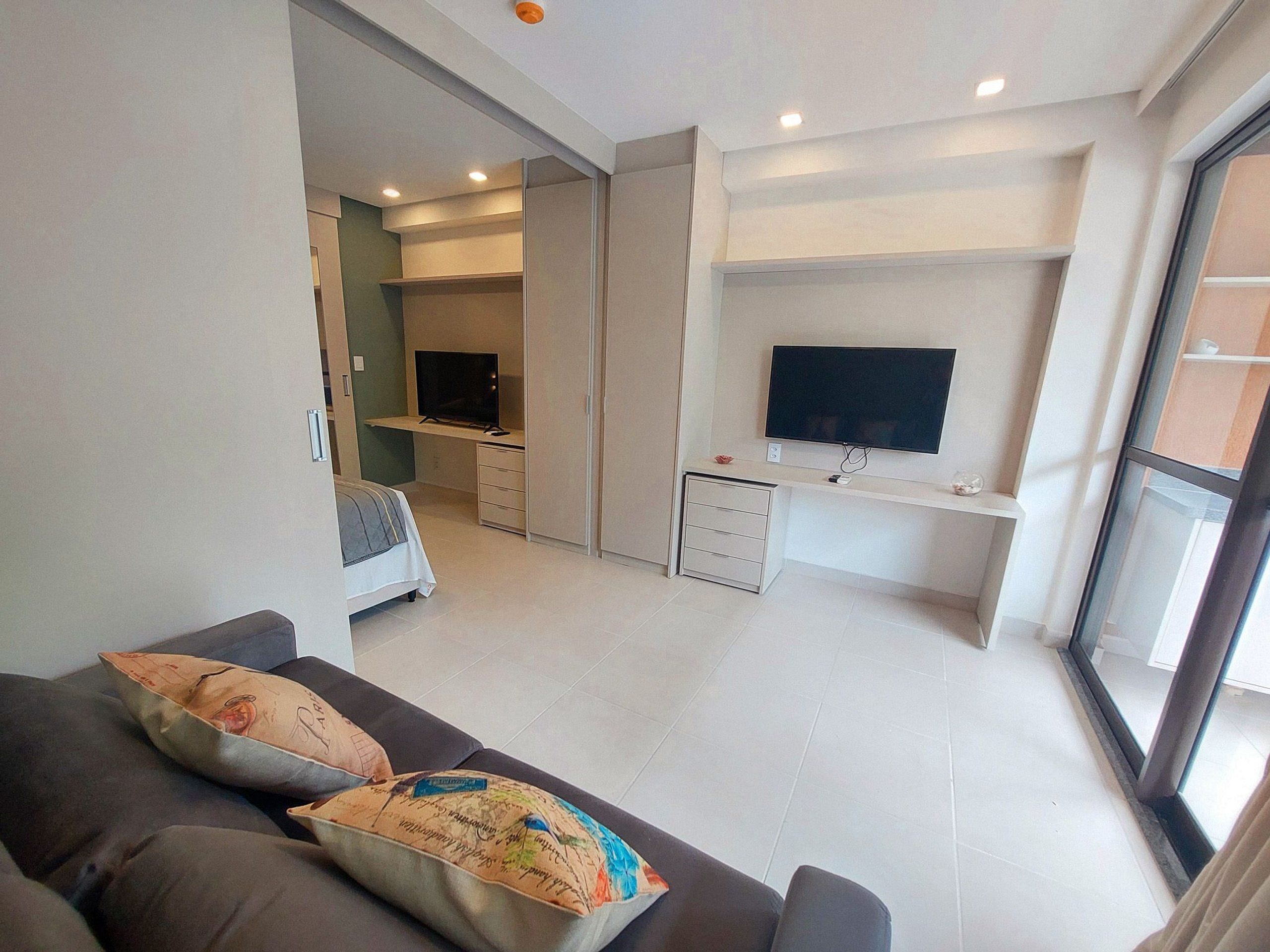Un salon moderne avec un canapé, un téléviseur et un espace bureau.