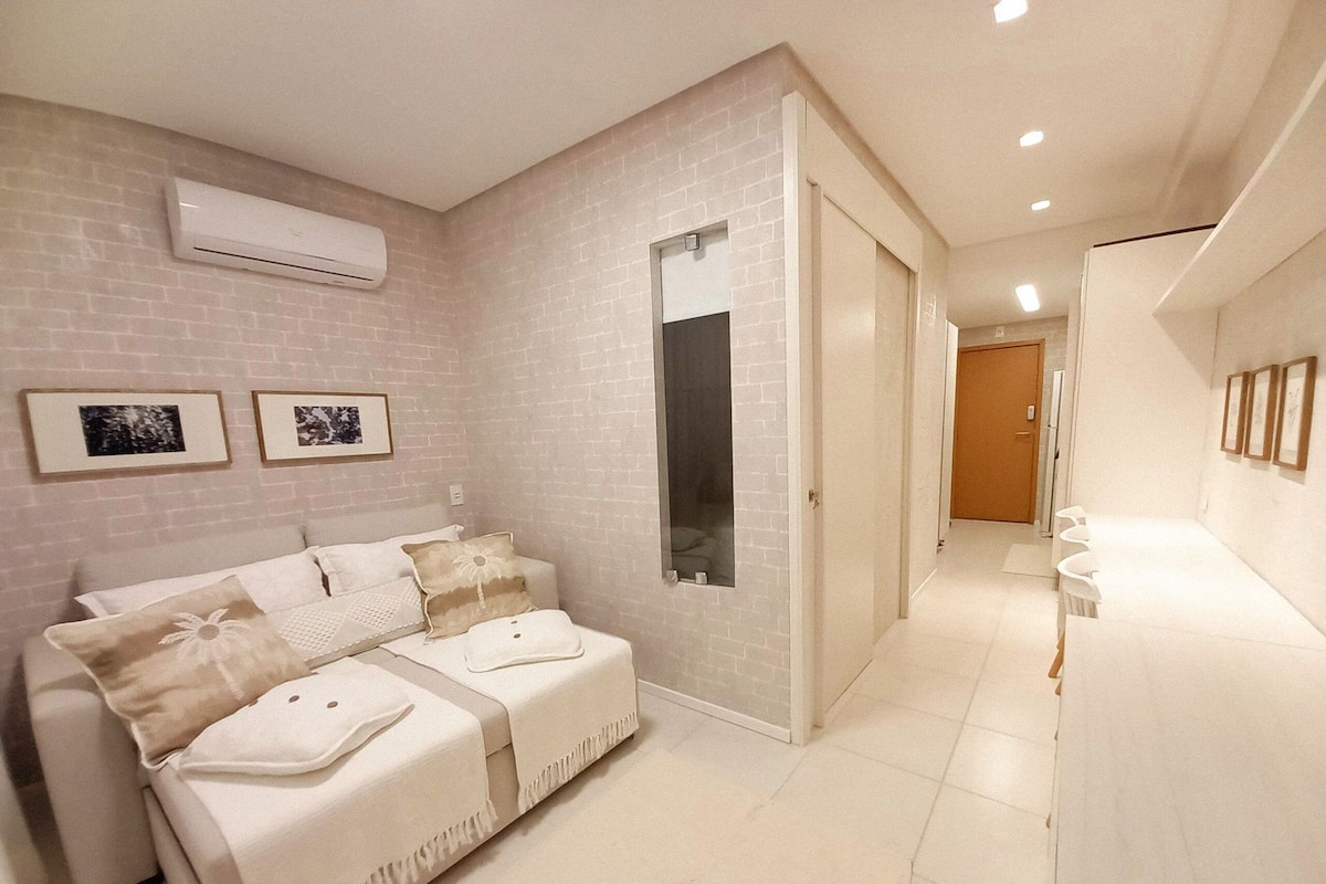 Una habitación de hotel moderna con cama, baño y pasillo.