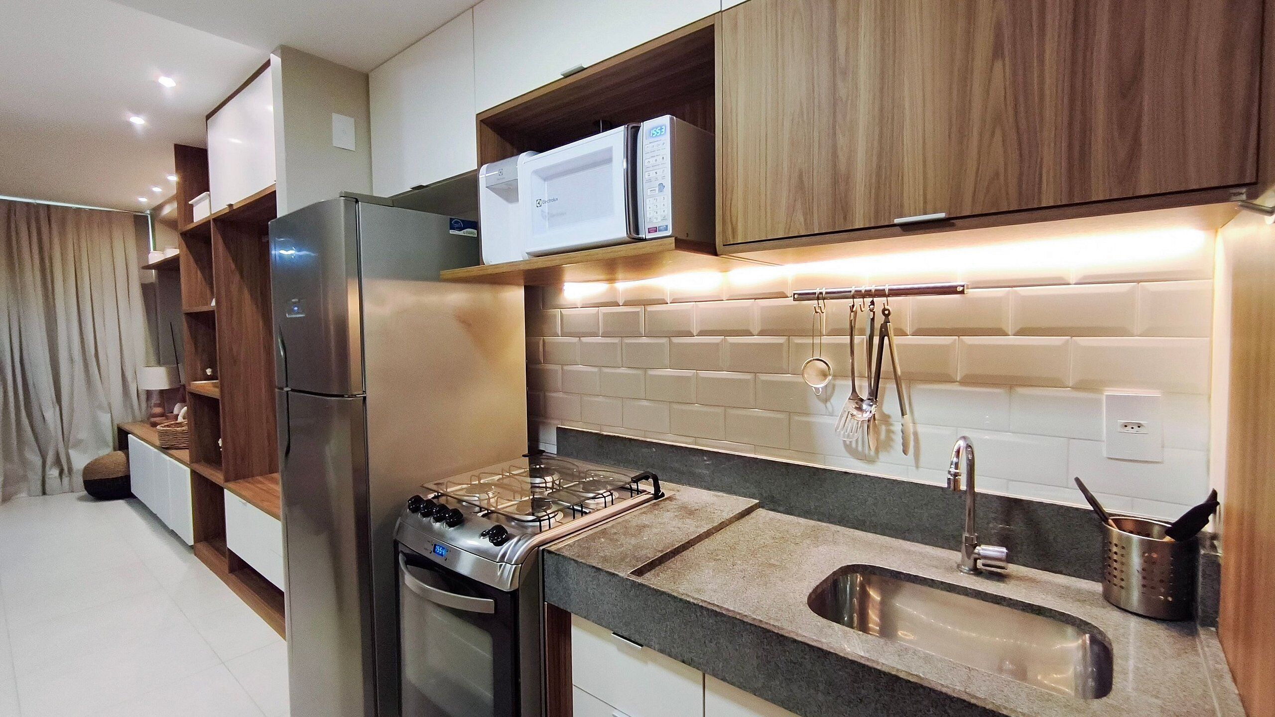 Una cucina moderna con elettrodomestici in acciaio inossidabile, piano cottura a gas, forno integrato e lavello.