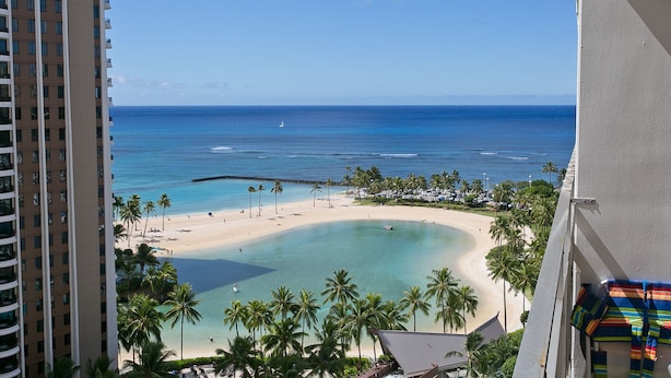 A high-rise hotel overlooking a beach with palm trees and clear blue water. - Waikiki Condo - Ocean View - Minutes from the Beach! (Honolulu)
