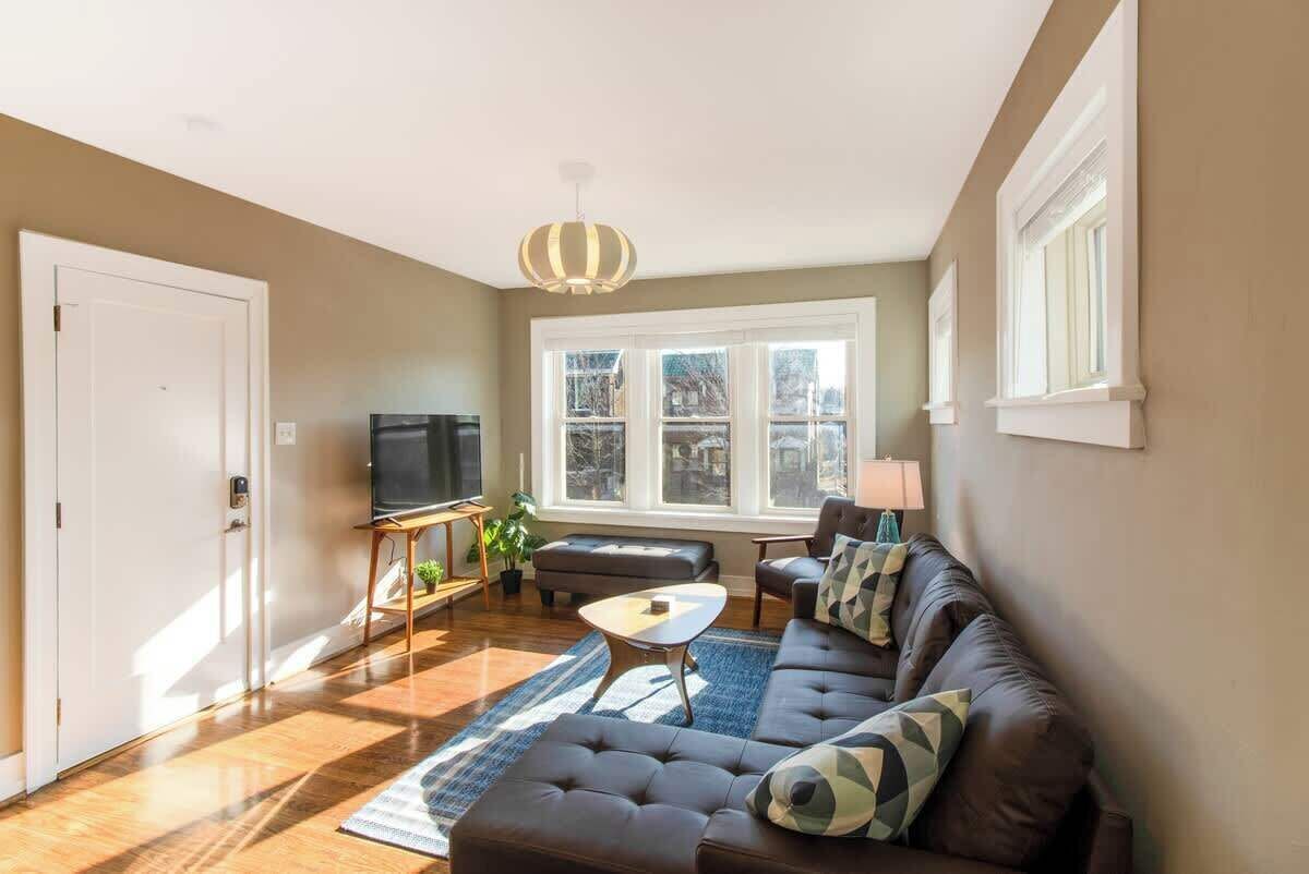 A living room with a sofa, coffee table, TV, and a large window.