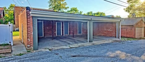 Ein eingeschossiges Gebäude mit überdachter Parkmöglichkeit, einer Ziegelhausfassade und einer Garage.