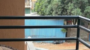 A balcony with a wicker sofa and a small table. - Exquisite City Apartments with hot tub (Nairobi)