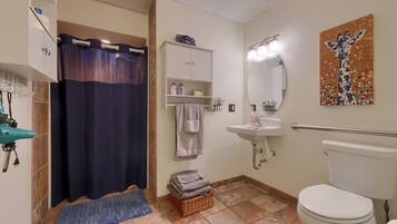 A bathroom with a shower, sink, toilet, and a towel rack.