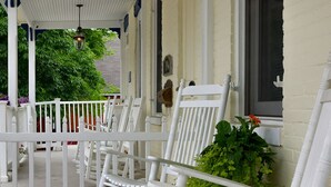 A porch with white rocking chairs and a potted plant. -  Stratton House-Unique Historic District Home-Backs to Culp's Hill-Ski Liberty! (Gettysburg)