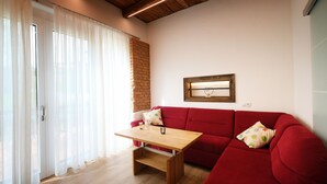 Una sala de estar con un sofá rojo, una mesa de centro de madera y una pared de ladrillo.
