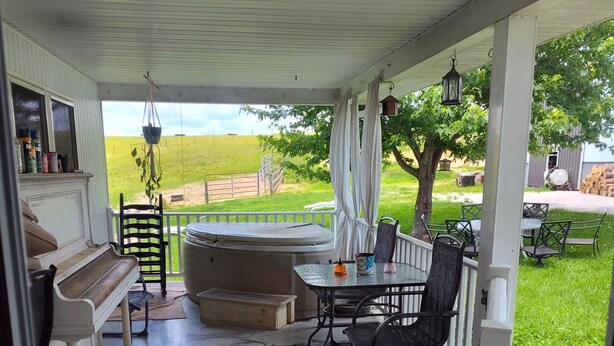A covered patio with a piano, a hot tub, and outdoor furniture. - The Bunkhouse @Dragonfly Ranch is made to make you feel like home away from home (Cub Run)