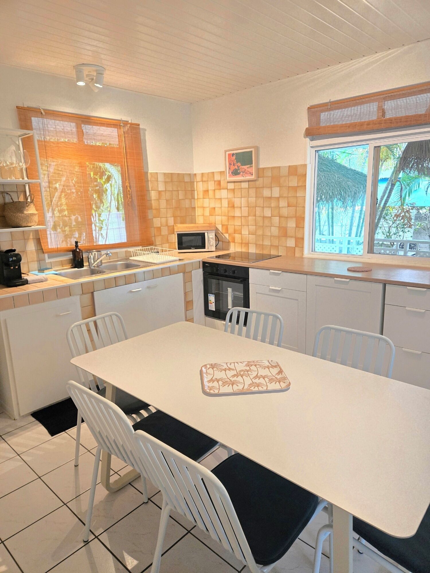 A compact kitchen with a dining table, chairs, a microwave, and a dishwasher.