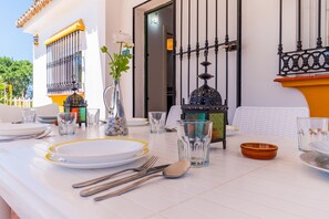 Une table à manger dressée avec des assiettes, des couverts, des verres et des objets de décoration.