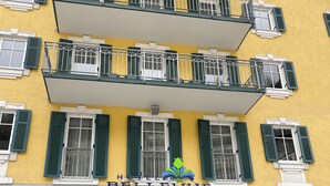 A hotel with a yellow facade, green shutters, and a sign that reads "HOTEL BELLEVUE A MONDI-HOLIDAY HOTEL". - Family apartment in the middle of Bad Gastein (Bad Gastein)