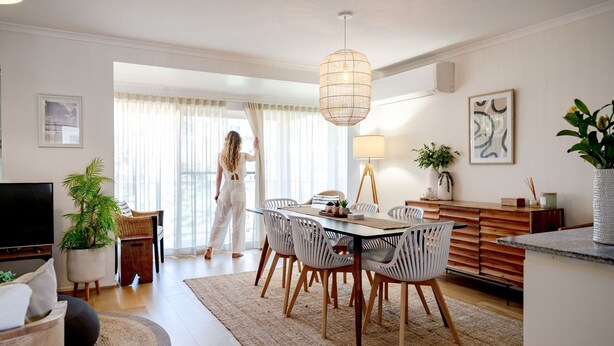 Een moderne woonkamer met een eethoek, een televisie en een balkon.