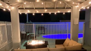 An outdoor seating area with a fire feature, surrounded by a white fence and string lights. - 1Bedroom guest suite NO CLEANING FEE w/free parking & WiFi for up to 4 guests (Las Vegas)