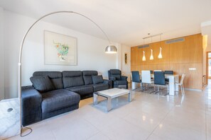 A modern living room with a sofa, a coffee table, and a dining area with chairs and a table. - Ca'n Beato in Son Carrió (Son Carrió)