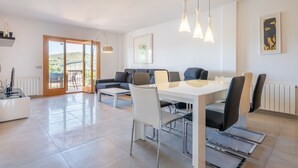 A modern living room with a sofa, dining table, chairs, and pendant lights. - Ca'n Beato in Son Carrió (Son Carrió)