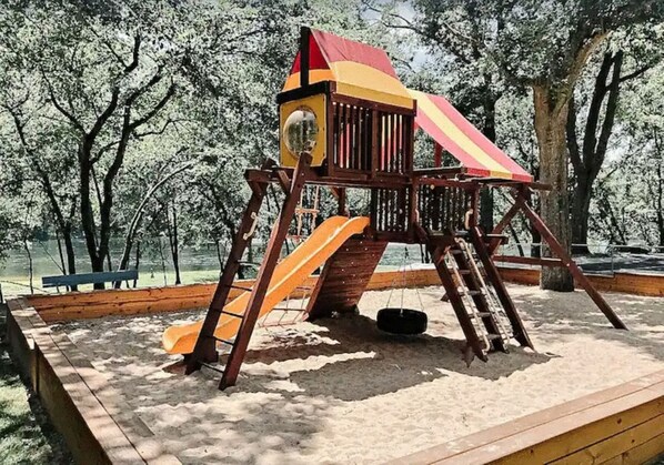 Relax in a charming swing set with a striped canopy, complete with a circular mirror.