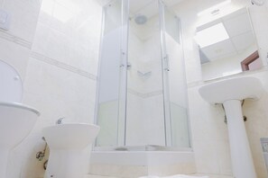 Habitación cuádruple clásica | Baño | Regadera, regadera tipo lluvia, toallas 