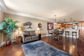A living room with a sofa, a coffee table, and a dining area with a table and chairs.