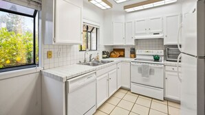 A modern kitchen with white cabinets, a double oven, a refrigerator, and a window with a view of greenery. - 2BR Close To Stanford, Medical Center and Hospital (Menlo Park)