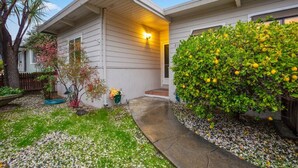 A single-story house with a covered porch, a small garden with a variety of plants, and a pathway leading to the entrance. - 2BR Close To Stanford, Medical Center and Hospital (Menlo Park)