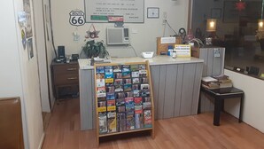 A reception desk with a sign indicating a check-out time of 10:00 AM. - 66 Motel (Holbrook)