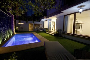 Una piscina al aire libre, sillones reclinables de piscina