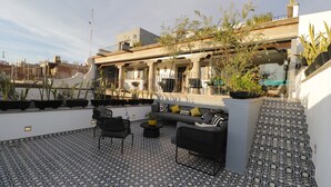 A rooftop terrace with patterned flooring, outdoor seating, and potted plants. - Hotel Boutique Casa Loreta (Querétaro)