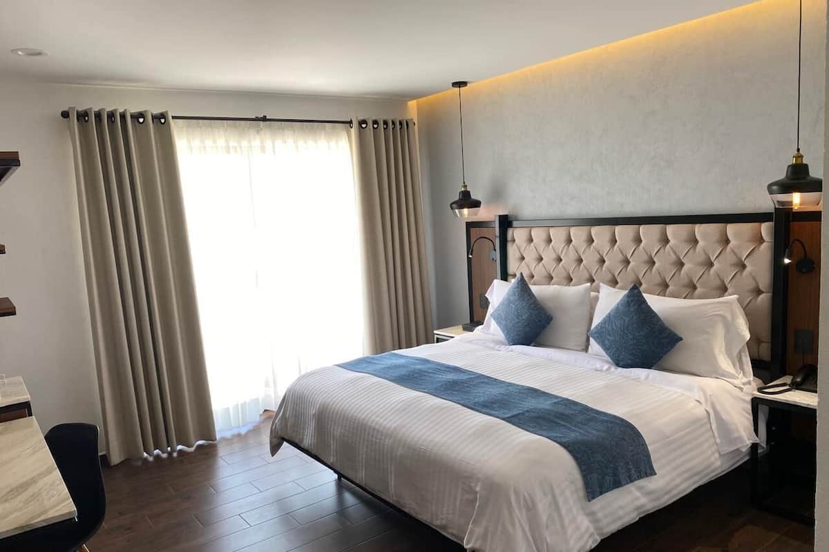 Une chambre d’hôtel avec un grand lit, un bureau et une chaise.