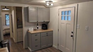 A compact kitchen with grey cabinets, a wooden countertop, and a coffee maker. - NEW! Beautiful Riverfront Home on 10 Acres! (Chesterton)
