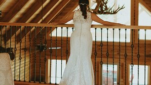 Une robe de mariée sur un plancher en bois, avec un plafond en bois et une rambarde.