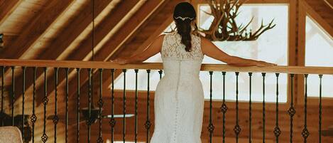 A wedding dress on a wooden floor with a wooden ceiling and a railing.