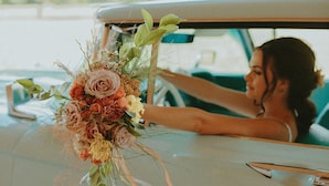 Une voiture ancienne ornée d’un arrangement floral sur le tableau de bord.