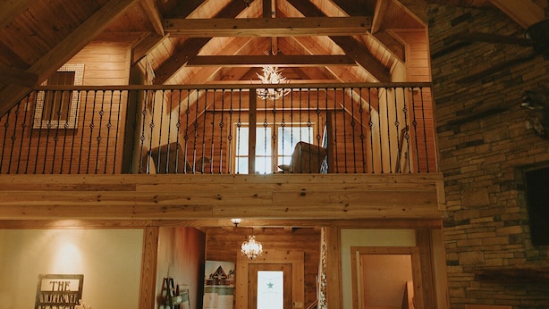 Une cabane en bois dotée d’un balcon, d’un lustre et d’une enseigne sur laquelle on peut lire : « The Wildflower Ranch ».
