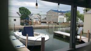 Ein Boot liegt an einem Steg mit Blick auf Häuser und einen weiteren Steg im Hintergrund.