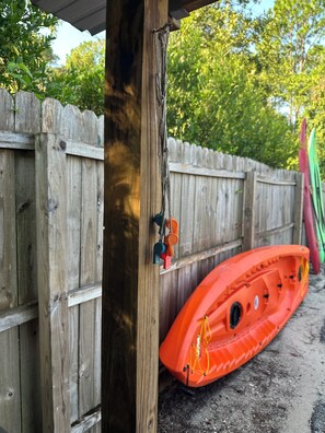 A wooden fence with a kayak and a paddle leaning against it. - “Divers Inn” on The Rainbow River (Dunnellon)